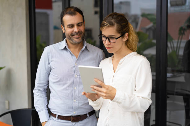 istock Serious female trainee showing her work to executive on tablet 1081209320