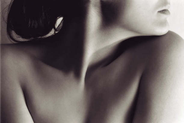 Portrait of Naked Woman's Neck and Face Close-up portrait of a woman standing near a white wall. neck photos stock pictures, royalty-free photos & images