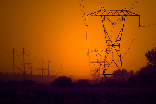 A closeup shot of high voltage electricity transmission towers at sunset