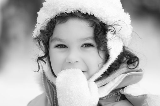 Daughter walk in forest. Child little girl throws up yellow autumn leaves. Kid standing and playing leaves in park. Family spending time together at sunset. Autumn holiday in nature. Black white photo