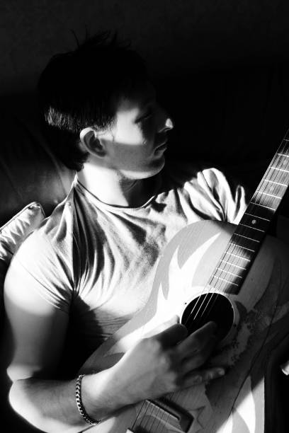 istock Young Man Playing Guitar, Low Key Black and White 108124974