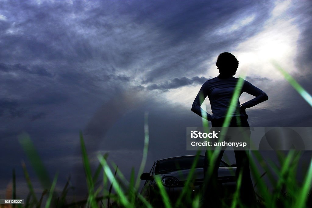 Jovem mulher em pé na frente de um carro na noite escura - Foto de stock de Adulto royalty-free