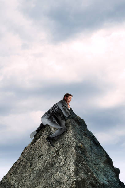 istock Businessman Clings To A Mountain Peak 1081256188