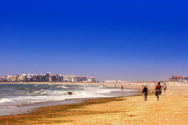 istock People Walking Along Beach With Blue Sky 108125629