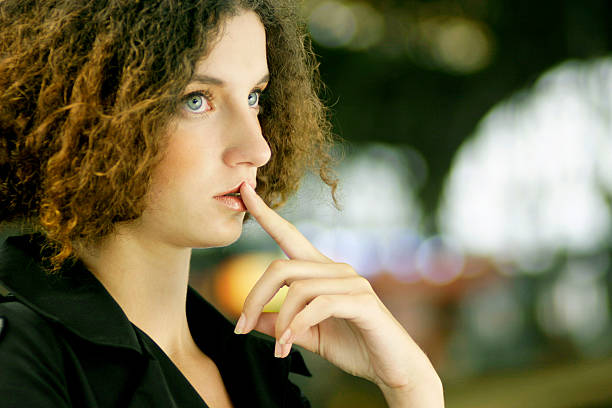 Pensive Young Woman Sitting and Looking Away stock photo