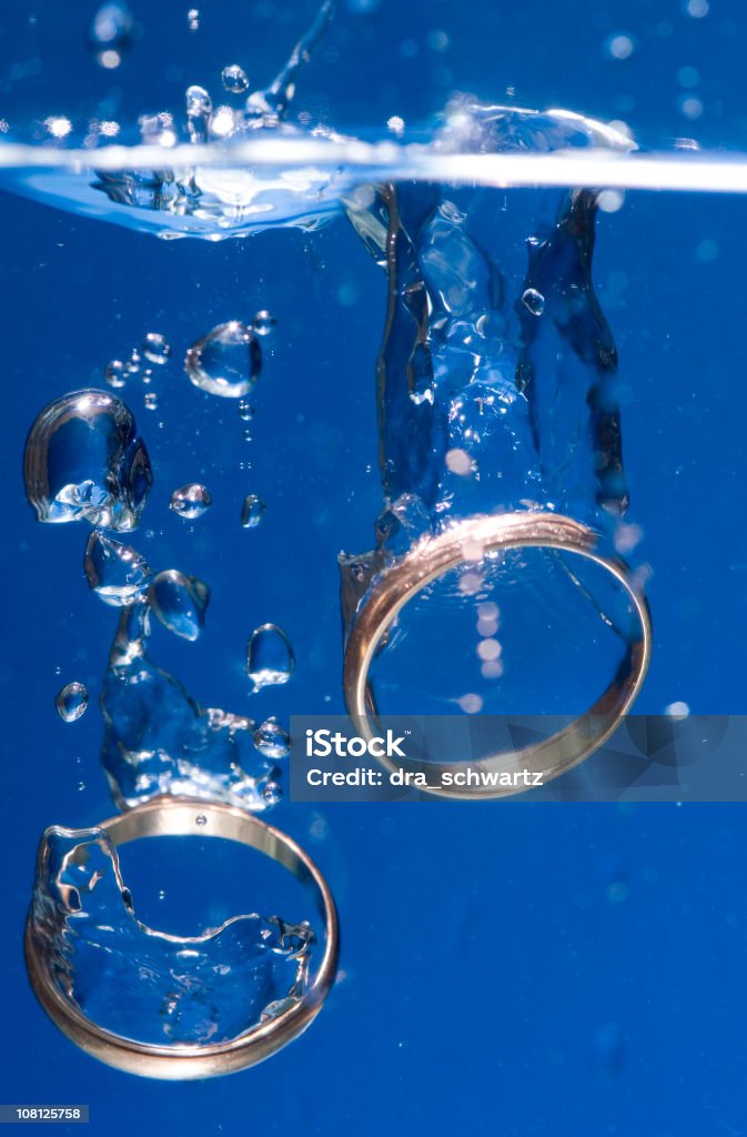 Dois anéis de casamento de ouro de mergulhar na água - Foto de stock de Aliança de casamento royalty-free
