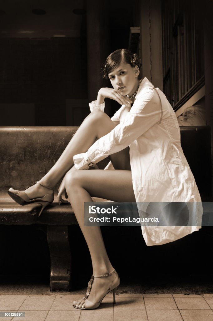 Retrato de joven mujer posando en banco, Sepia - Foto de stock de A la moda libre de derechos