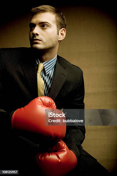 Businessman Wearing Boxing Gloves On Brown Background Stock Photo - Download Image Now