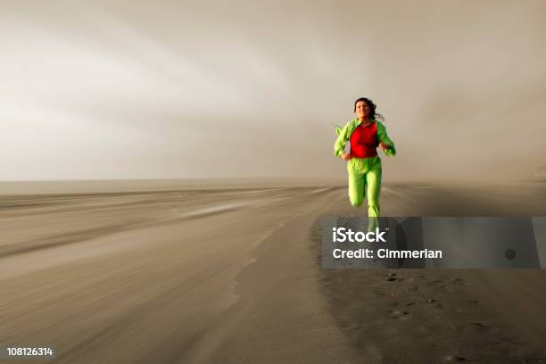 Foto de Jovem Mulher Correndo Em Frente Na Praia e mais fotos de stock de A caminho - A caminho, Adulto, Areia