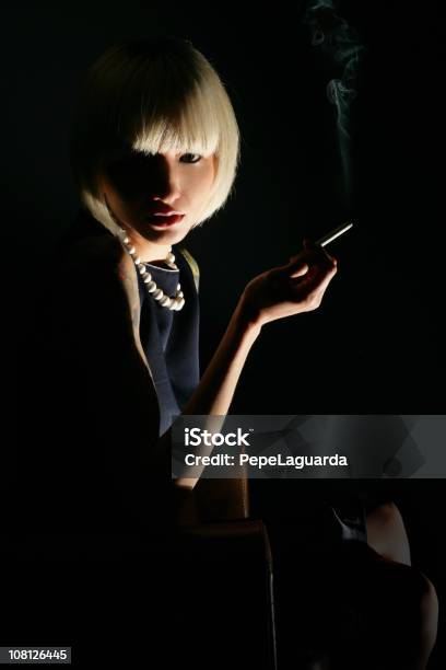 Ritratto Di Giovane Donna Fuma Sigaretta Chiave Di Basso - Fotografie stock e altre immagini di Donne