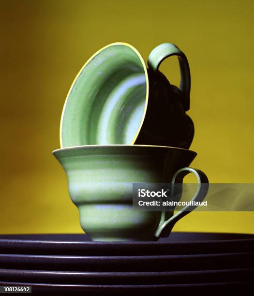 Empilhados Teacups E Placas Sobre Fundo Amarelo - Fotografias de stock e mais imagens de Cerâmica - Cerâmica, Chávena, Chávena de Chá