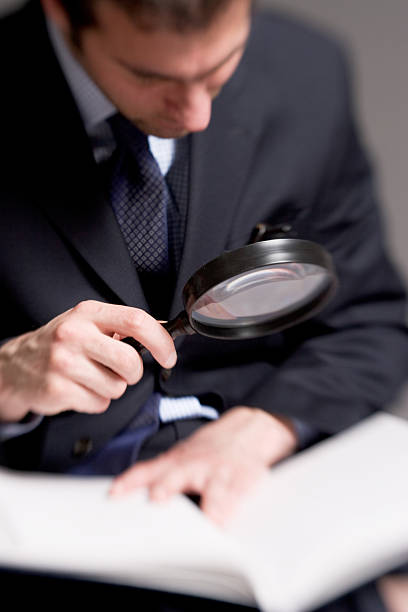 istock Blurred Effect of Businessman Using Magnifying Glass with Book 108126818