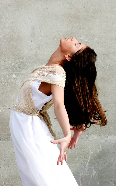 istock Young Woman in Dancer's Pose Against Cement Wall 108126992