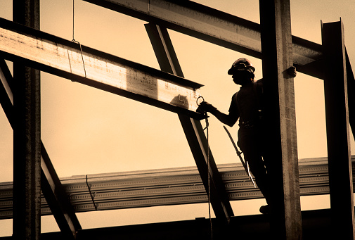 Steel workers puts the finishing fasteners on a bridge across Rubicon Creek, El Dorado National Forest, California.