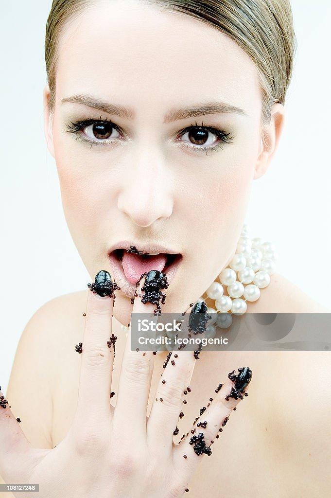 Mujer joven relamerse el Caviar de los dedos - Foto de stock de Collar de perlas - Joyas libre de derechos
