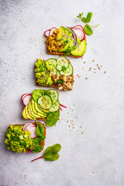 istock Avocado toasts with different toppings, top view, white background, copy space. 1081272510