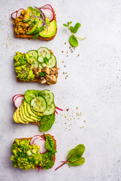 istock Avocado toasts with different toppings, top view, white background. 1081272690