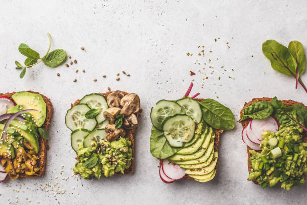 istock Avocado toasts with different toppings, top view, white background, copy space. 1081273118