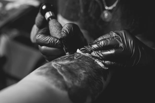 brazo del hombre tatuaje artista - tattoo machine fotografías e imágenes de stock