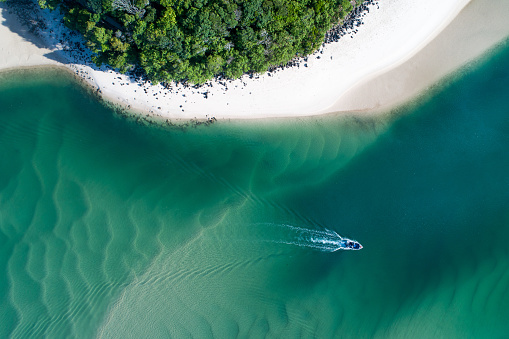 Aerial view of a beach at sunrise with a kayak, sand banks
