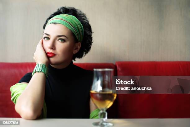 Photo libre de droit de Portait De Femme Assise À Une Table Avec Une Boisson En Verre banque d'images et plus d'images libres de droit de Bandana