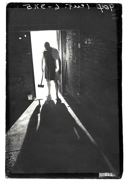 In the shadows of a madman. 

Photo is grunge with plenty of wear and tear and texture.