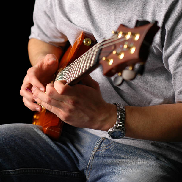 istock Man Sitting and Playing Electric Guitar, Isolated on Black 108127850