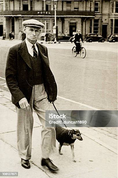 Senior Anni30 Uomo Che Cammina Con Il Cane In Strada Vintage - Fotografie stock e altre immagini di Stile retrò