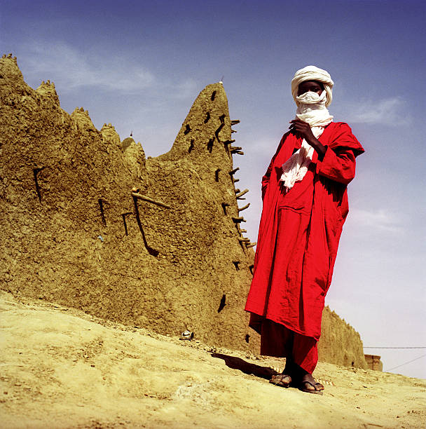 Man Wearing Tuareg and Red Tunic in Desert Village  people covered in mud stock pictures, royalty-free photos & images