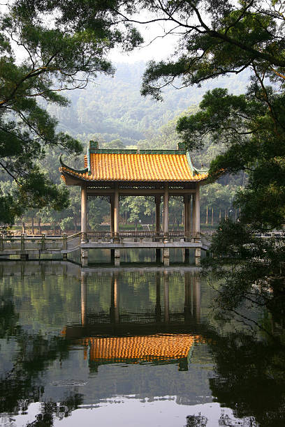 Yangzhou, China - April 9, 2024. A man walking on bridge in front of Chinese pavilion in Yangzhou Guesthouse, China
