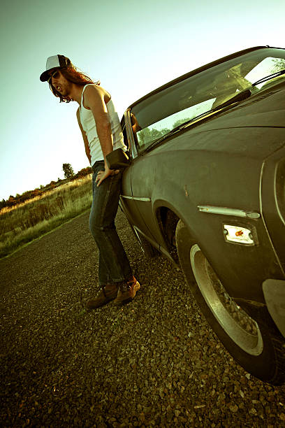 istock Hillbilly Man Leaning Against Car on Road 108128460
