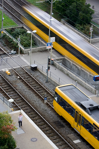 Trains in a station as seen from above. On etrain is leaving in motion blur