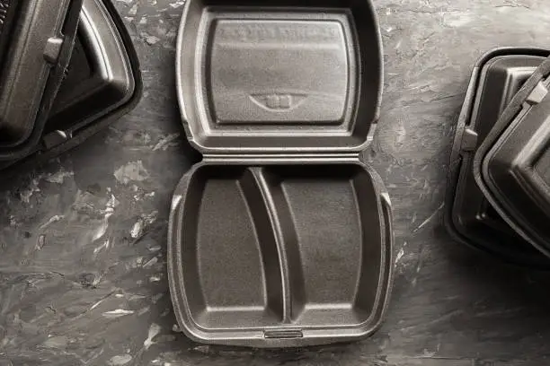 Opened black styrofoam fast food container, view from above. Top view