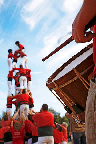 castellers und mann spielt drum an einem sonnigen tag - castellers stock-fotos und bilder