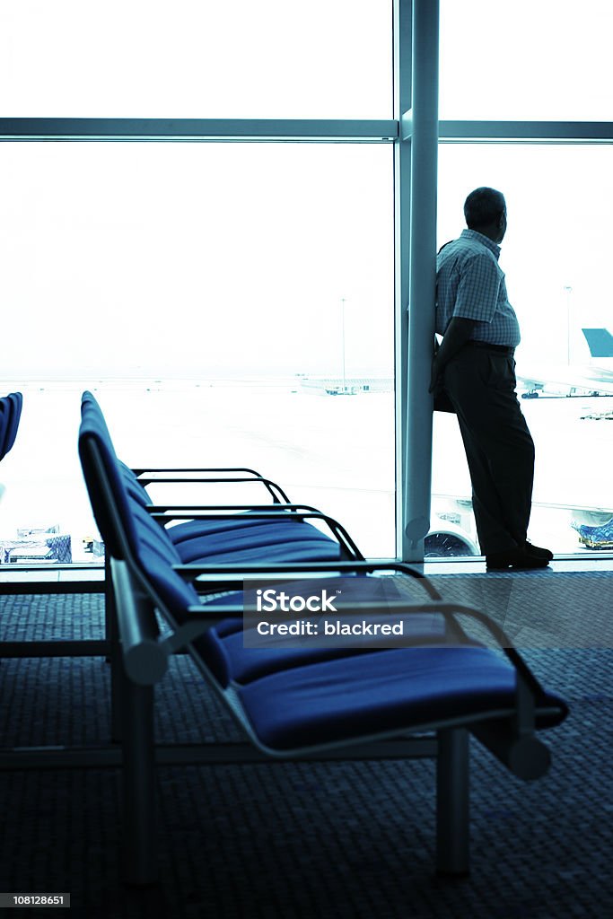 Мужчина выглядывает из окна и ждать в аэропорту терминал - Стоковые фото Аэропорт роялти-фри