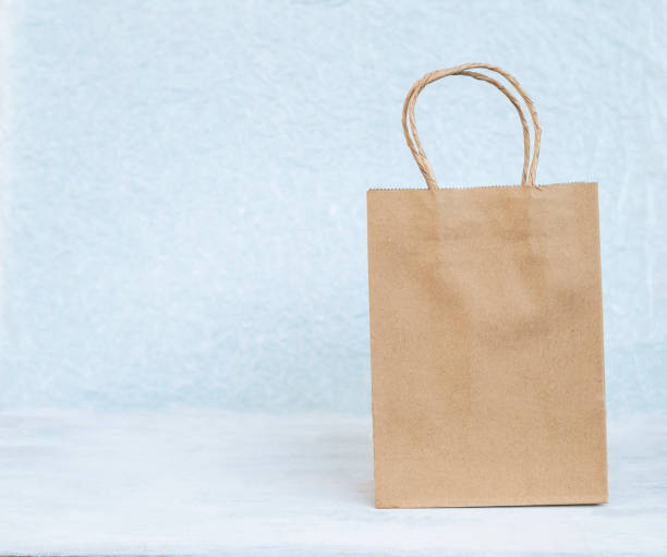 istock Blank brown paper bag over blurred white texture background 1081287304