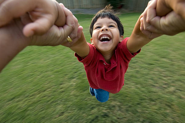 Dad Spinning Little Boy in Air