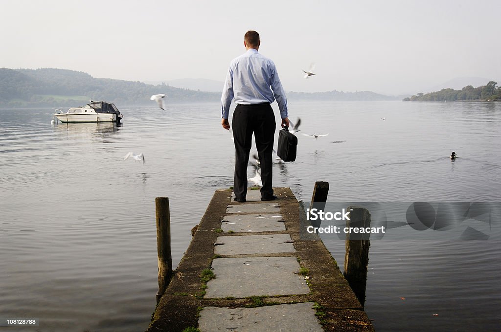 Homme d'affaires debout lac sur la jetée - Photo de Être debout libre de droits