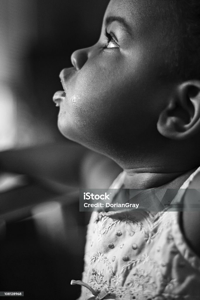 Retrato de niña bebé mirando hacia arriba, blanco y negro - Foto de stock de Bebé libre de derechos
