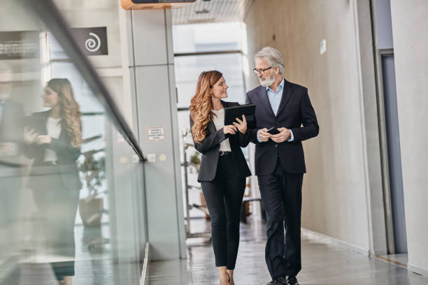 istock Co-workers discussing an important matter on a empty hallway. Co-workers discussing an important matter on a empty hallway. 1081291364