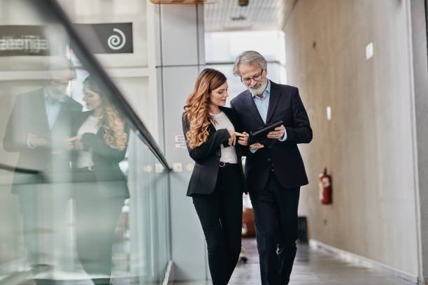 istock Co-workers discussing an important matter on a empty hallway. Co-workers discussing an important matter on a empty hallway. 1081291720