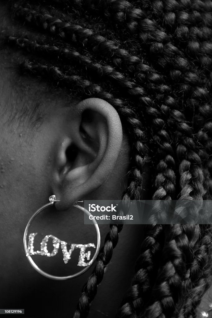 Donna che indossa orecchini che parla di "amore", bianco e nero - Foto stock royalty-free di Treccine