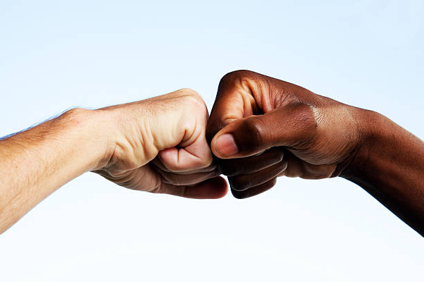istock Black and white fists touching 108129279