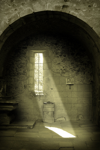 Light in the window of a dungeon in a stone old castle.