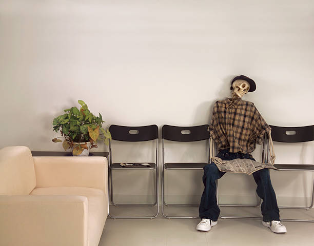 Skeleton Man Sitting Waiting Room with Newspaper stock photo