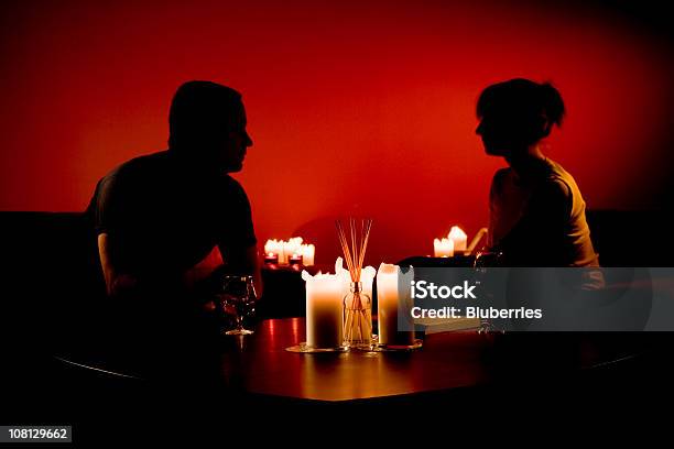 Silhouette Des Mannes Und Der Frau Sitzt Mit Verschiedenen Kerzen Stockfoto und mehr Bilder von Zweiertisch
