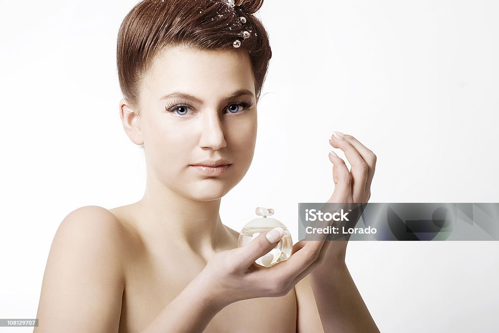 Jeune femme tenant une bouteille de parfum - Photo de Vue de face libre de droits