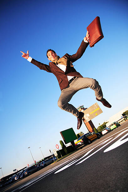 szczęśliwy biznesmen skoki na parking - men businessman jumping levitation zdjęcia i obrazy z banku zdjęć