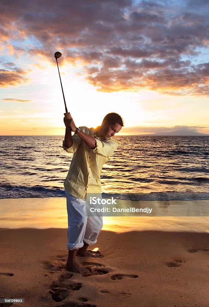Hombre campos de golf en la playa al atardecer - Foto de stock de Swing de golf libre de derechos