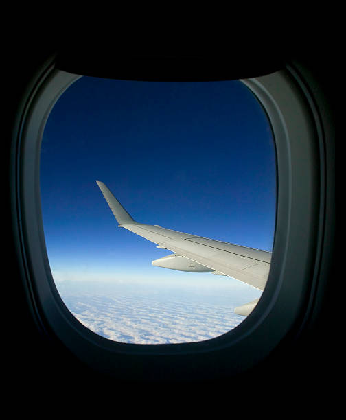istock Looking Out of Airplane Window at Wing Above Clouds 108130043